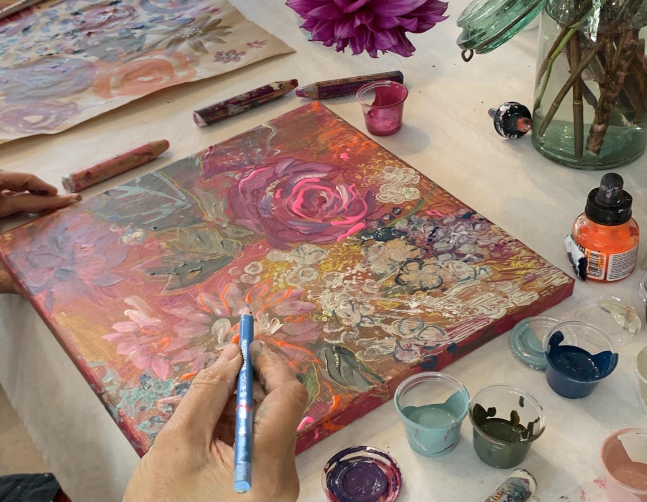 Woman painting a floral canvas