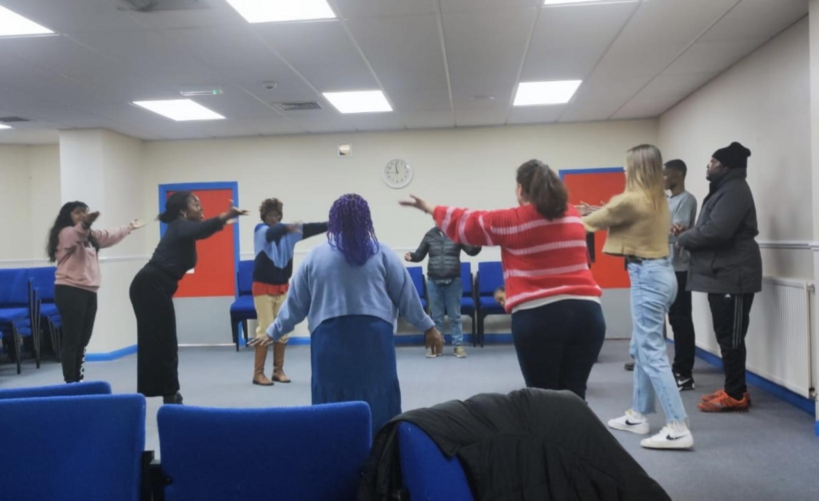 A group of people are practising dance in a circle